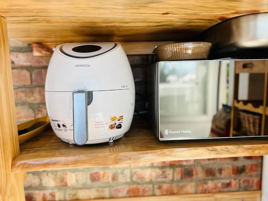 White air fryer and Russell Hobbs toaster on wooden kitchen shelf