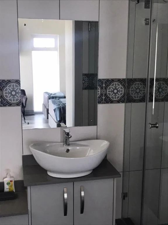 Modern bathroom with white vessel sink and large mirror