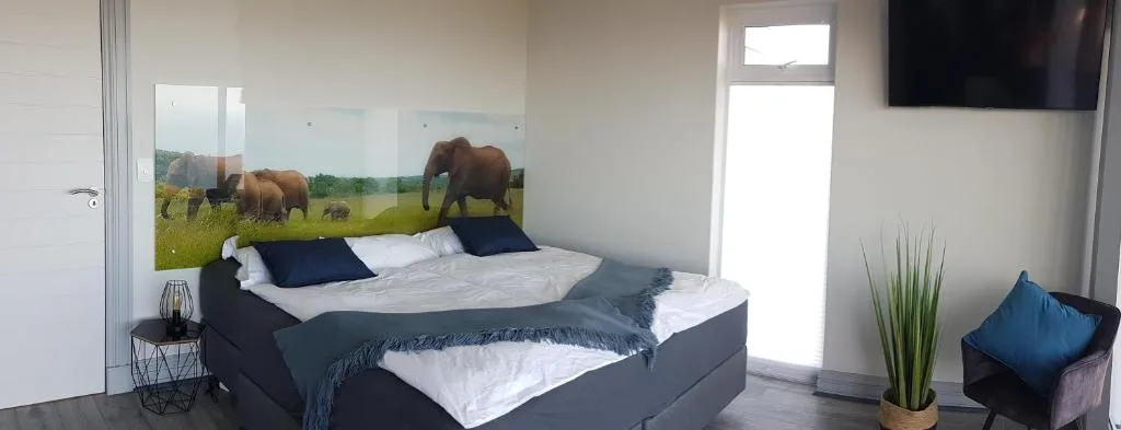 Modern bedroom with elephant artwork headboard and bright natural light