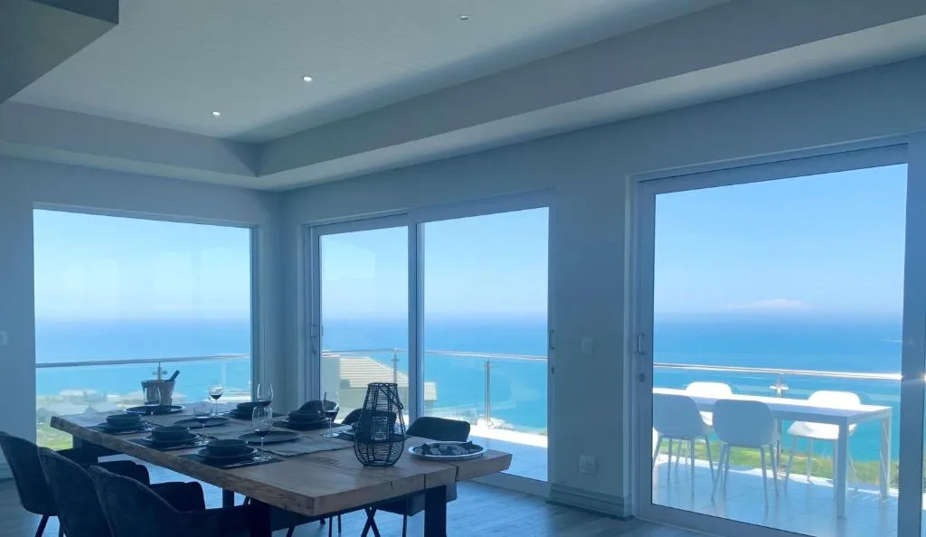Modern dining area with ocean views through floor-to-ceiling windows
