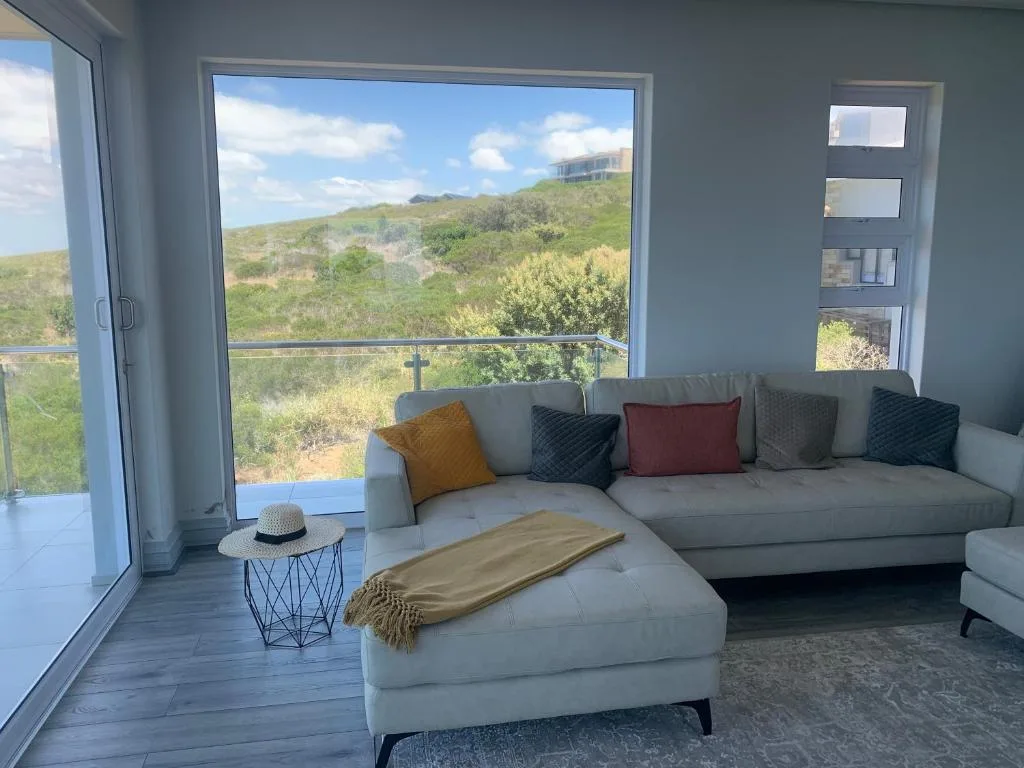 Modern living room with gray sofa, mountain views through large windows