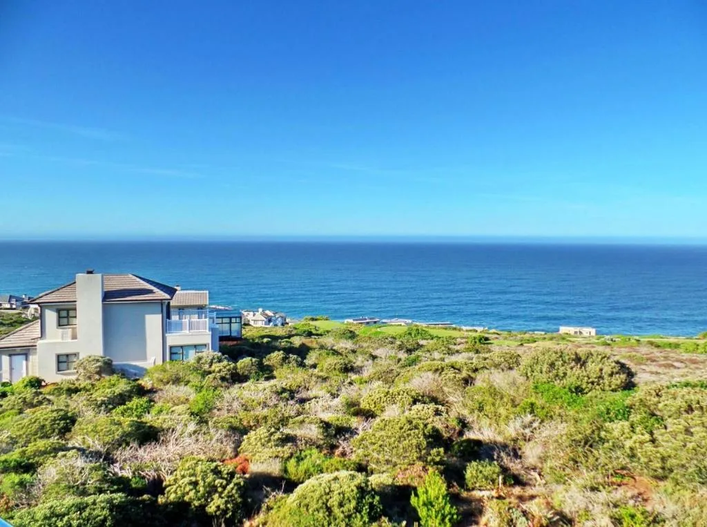 Modern villa overlooking ocean and coastal vegetation on Garden Route