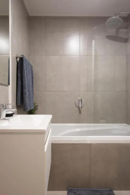 Modern bathroom with white vanity, bathtub, and rainfall shower head