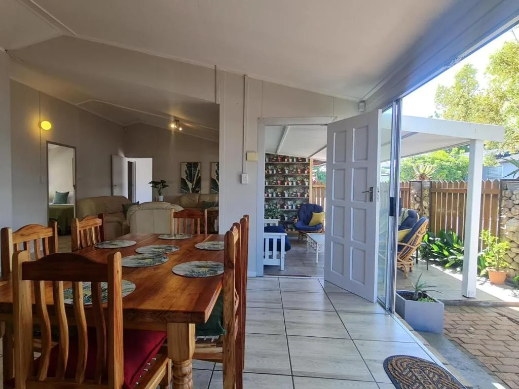 Wooden dining table with place settings and open garden doors beyond