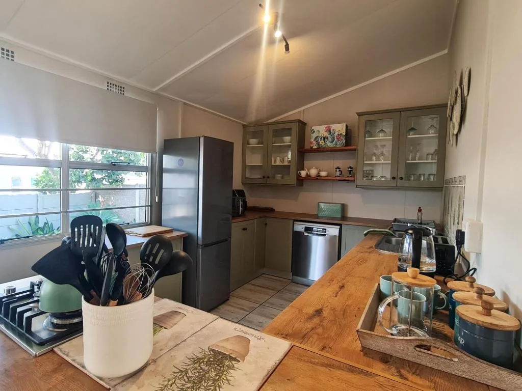 Well-equipped kitchen with wooden counter, stainless steel appliances, and glass-fronted cabinets