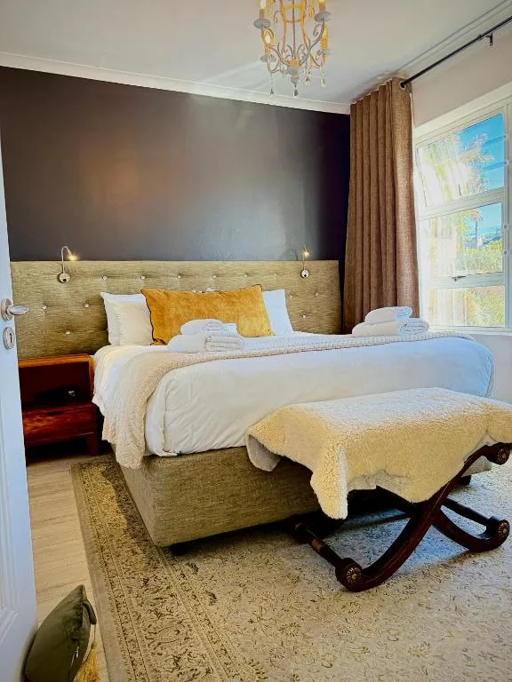 Elegantly styled bedroom with upholstered headboard, white bedding, and gold accents