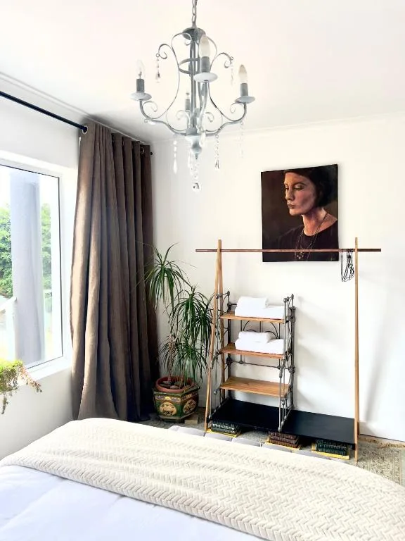 Bright bedroom with bed, elegant chandelier, and modern decor accents