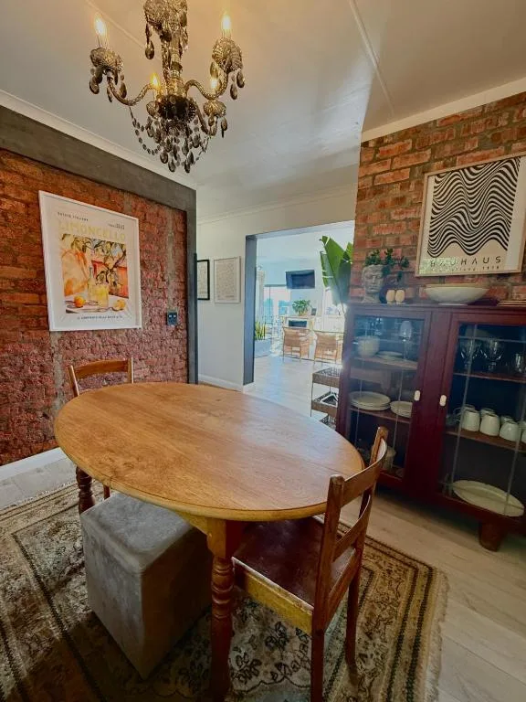 Elegant dining room with oval wooden table and brick accent walls