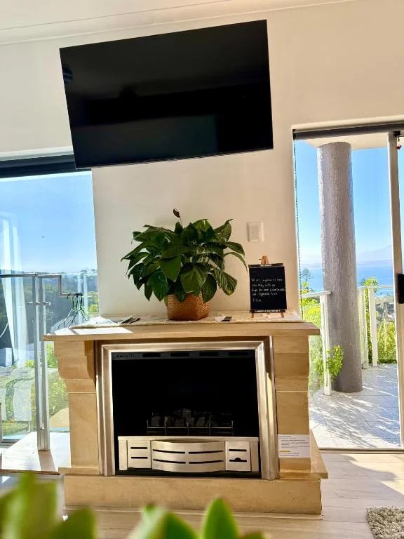 Modern lounge with fireplace, wall-mounted TV, and scenic ocean views