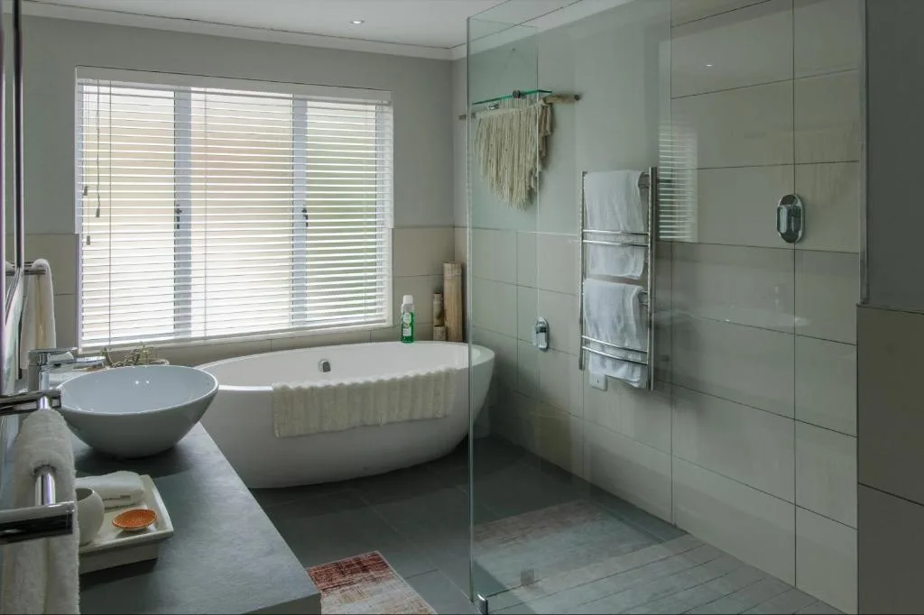 Modern bathroom with freestanding bathtub, walk-in shower, and natural light