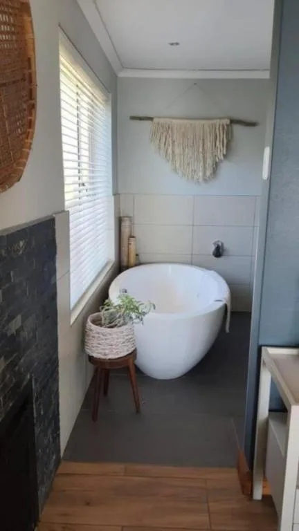 Modern bathroom with freestanding white soaking tub and natural light