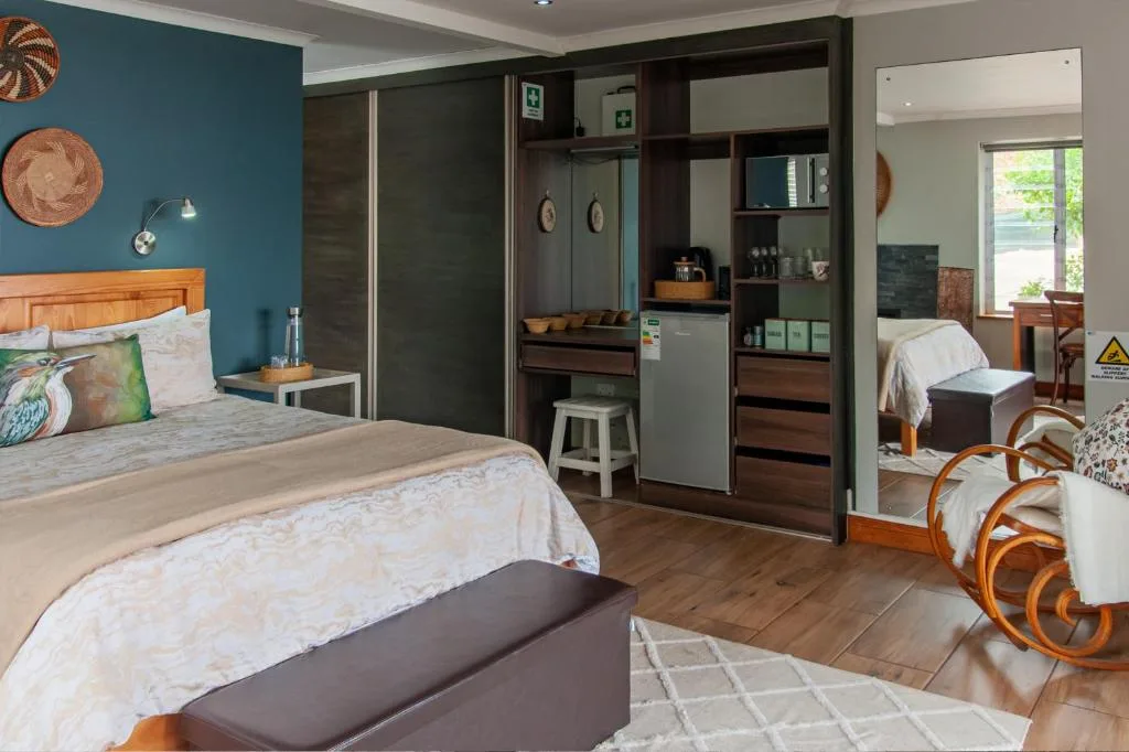 Spacious bedroom with teal walls, wooden bed, and built-in wardrobe storage