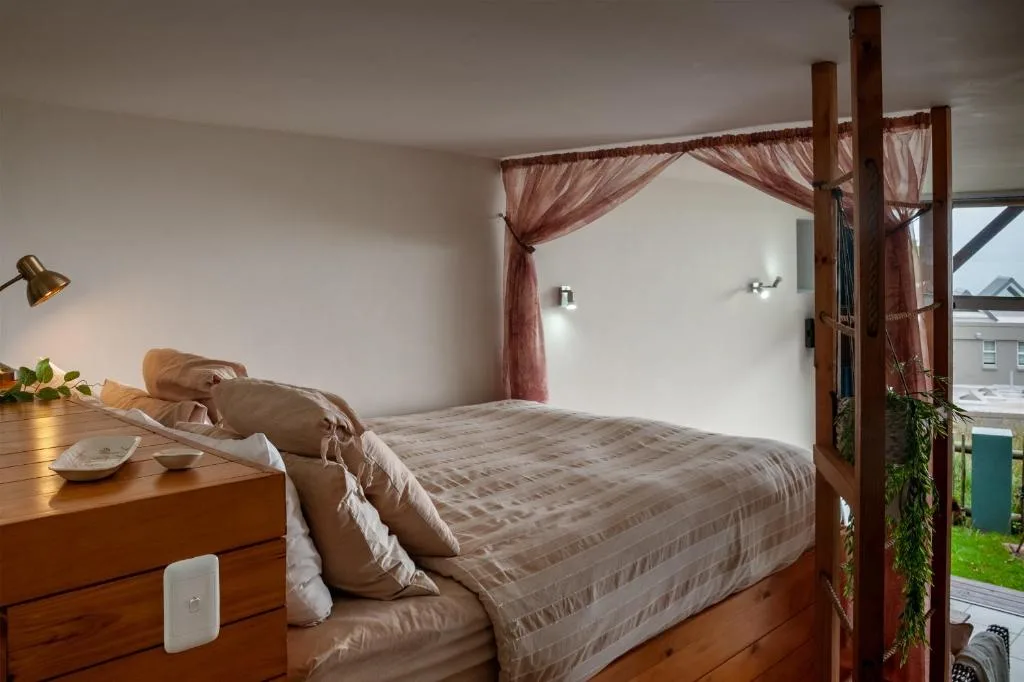 Spacious bedroom with four-poster bed and burgundy canopy drapes