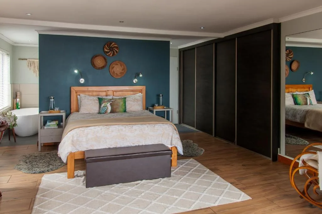 Spacious bedroom with wooden bed frame and teal accent wall decor