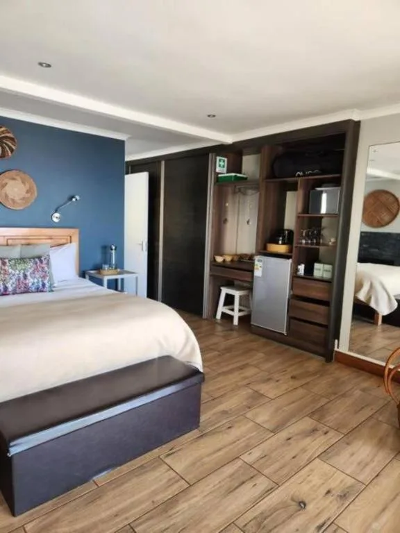Modern bedroom with queen bed, blue accent wall, and built-in wardrobe storage