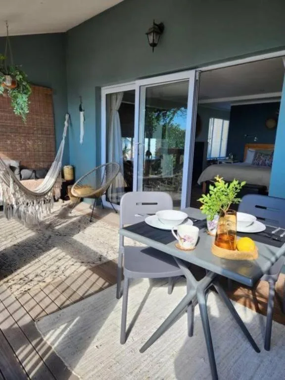 Outdoor patio with dining table, hammock, and sliding glass doors