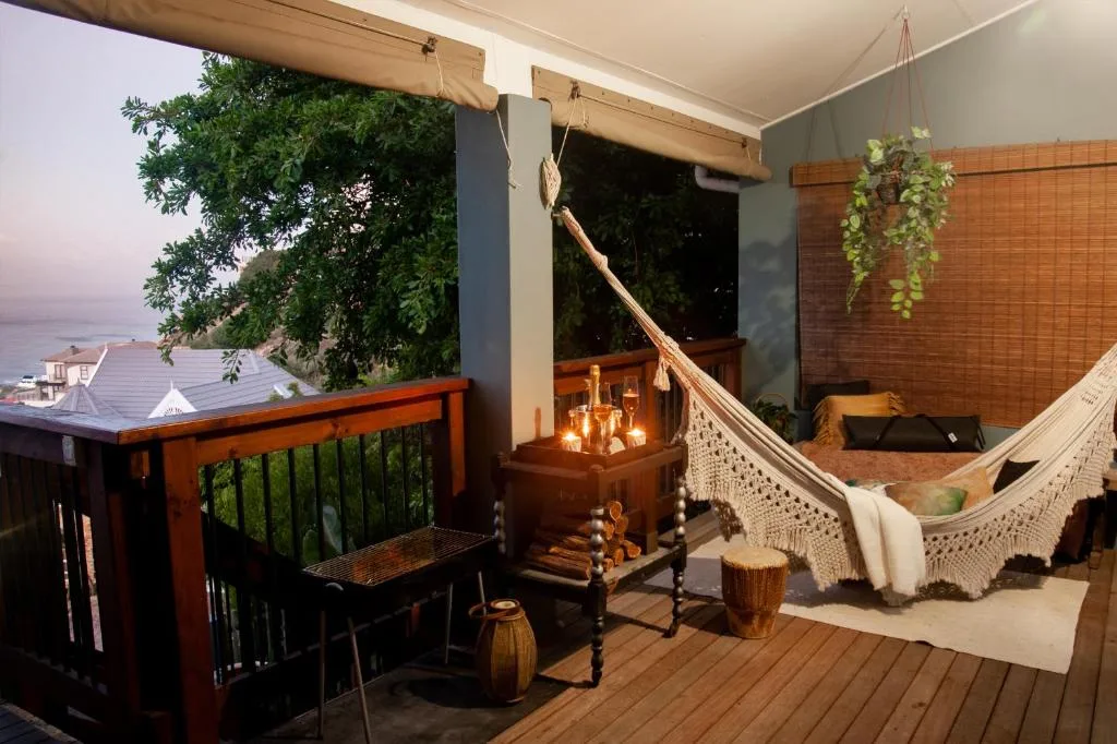 Waterfront deck with hammock, seating, and ocean view at dusk