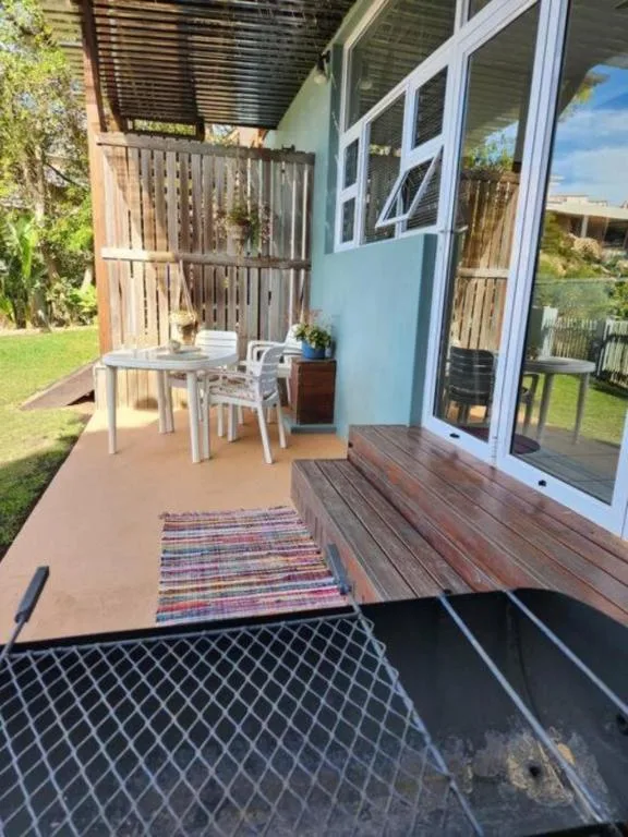 Outdoor patio with wooden deck, dining table, and garden views