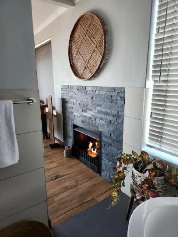 Modern fireplace with grey brick surround and woven oval wall art