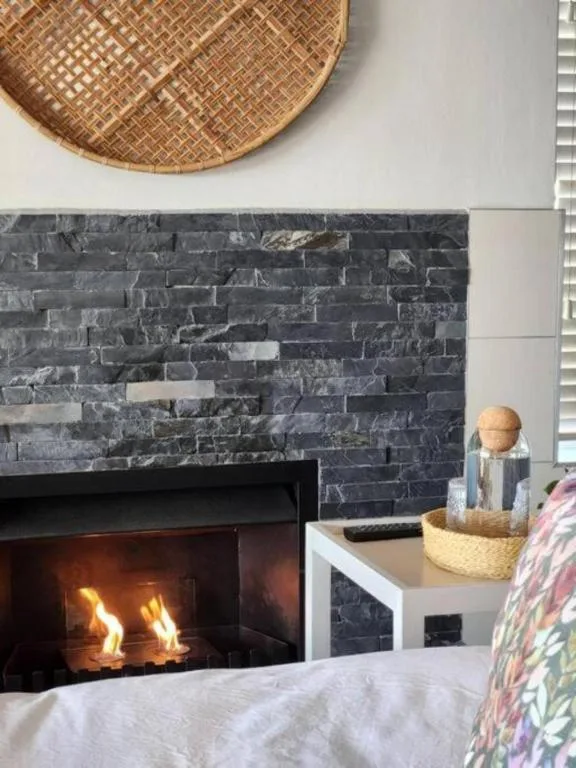 Modern fireplace with dark stone accent wall and woven basket decoration