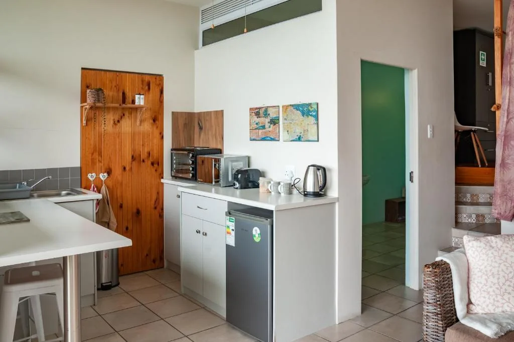 Modern kitchen with white cabinetry, dishwasher, and wooden pine door accents