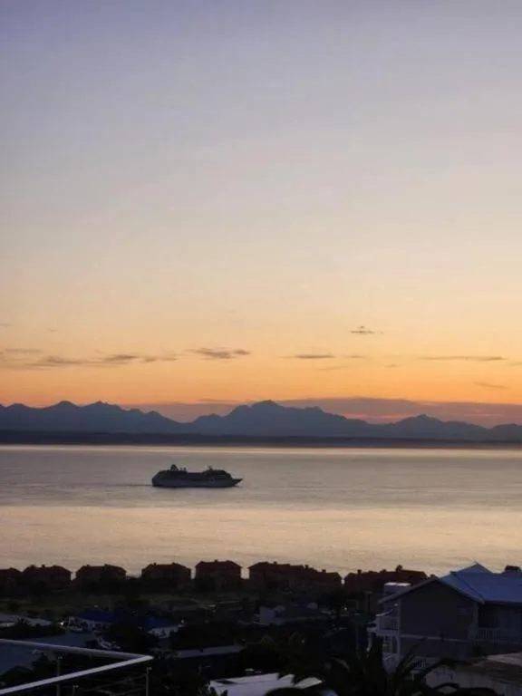 Sunset view of mountains and ocean with small island silhouette