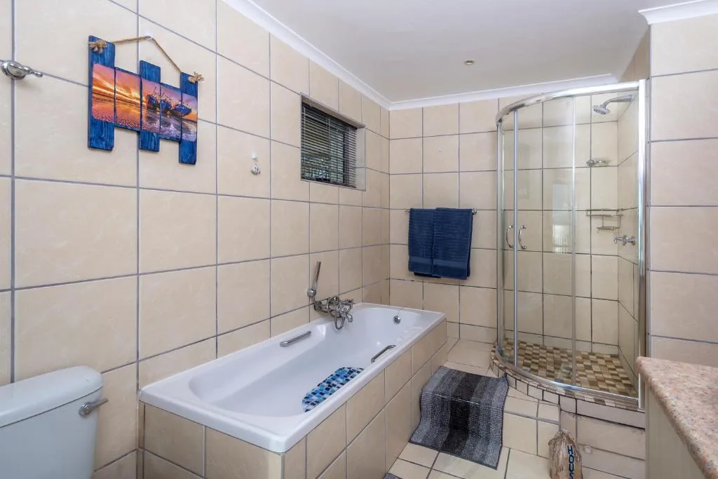 Modern bathroom with bathtub, shower cubicle, and decorative wall art