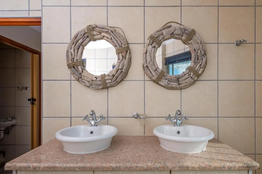 Dual vanity bathroom with rope-framed mirrors and stone countertop