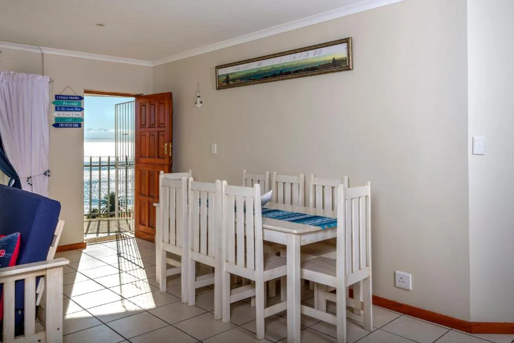 Child's bedroom with white bunk beds and balcony access overlooking water