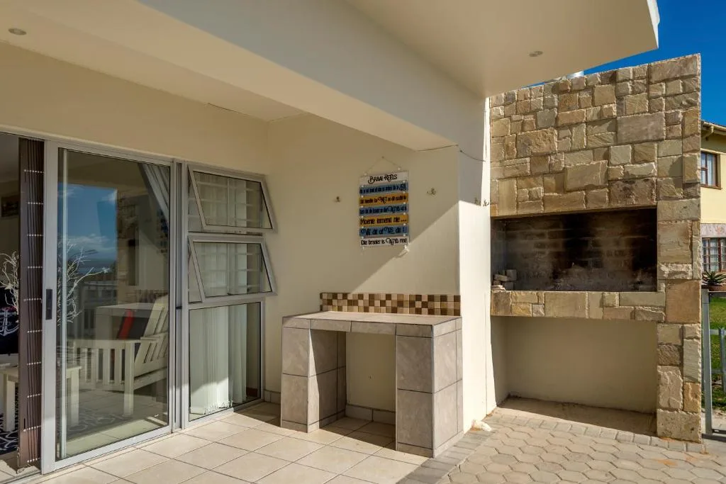 Outdoor patio area with built-in braai and sliding glass doors