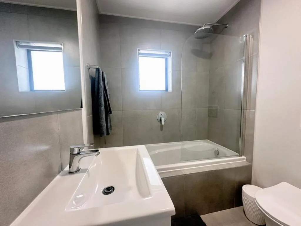 Modern bathroom with sink, bathtub, shower enclosure, and toilet