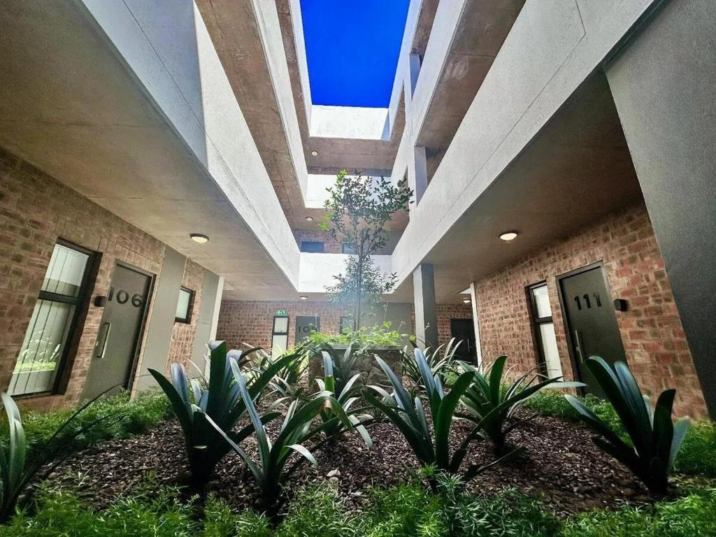 Modern courtyard entrance with brick walls and skylights overhead