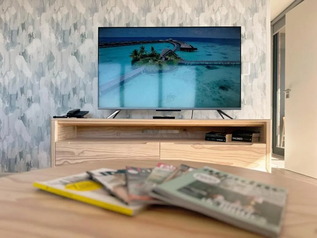 Modern lounge with wooden TV unit displaying tropical island scenery