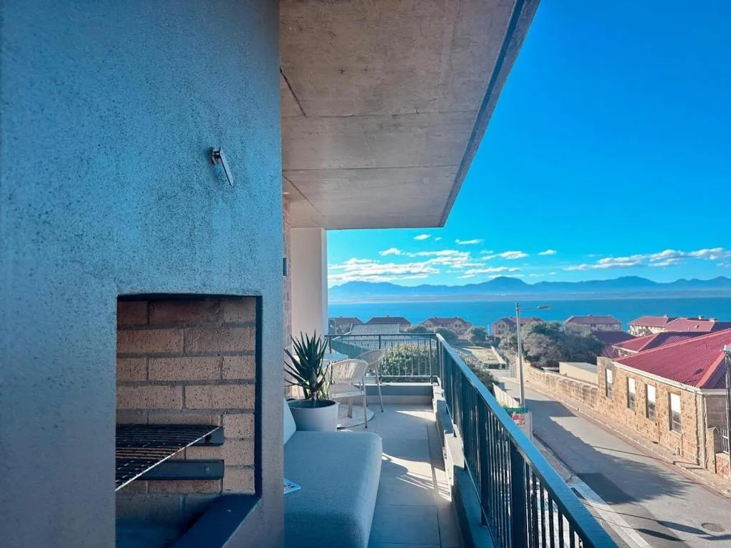 Expansive ocean and mountain vista from contemporary seaside apartment deck