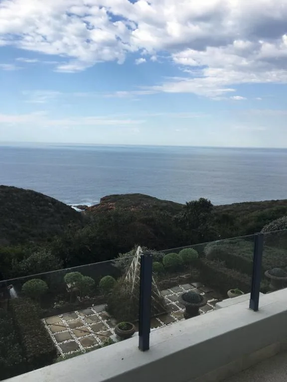Ocean vista from elevated deck with coastal hills and cloudy sky