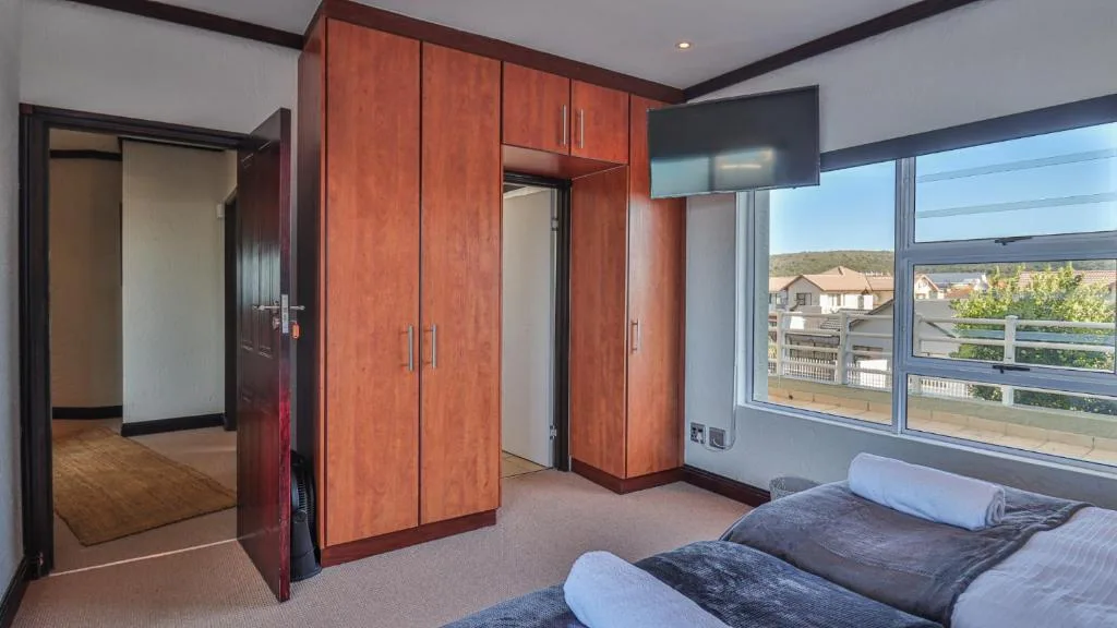 Spacious bedroom with twin beds, built-in wardrobe, and window views