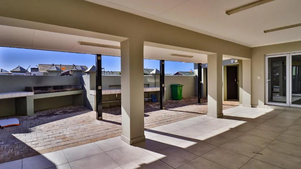 Spacious covered rooftop patio with paved flooring and supporting pillars