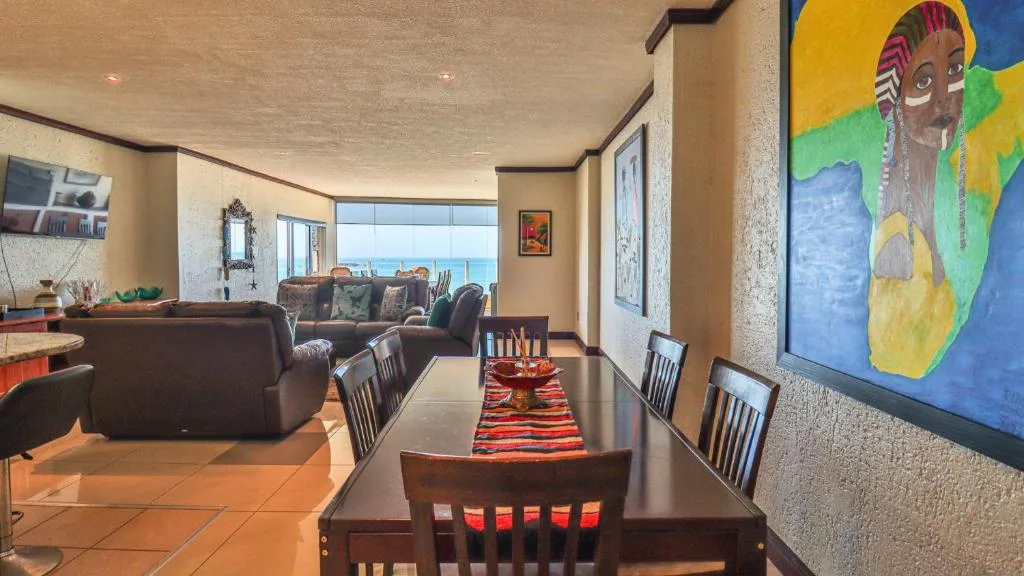 Dining table with ocean view and colorful modern art on walls