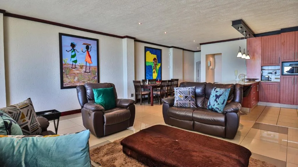 Open-plan lounge with brown leather sofas and colorful artwork on walls