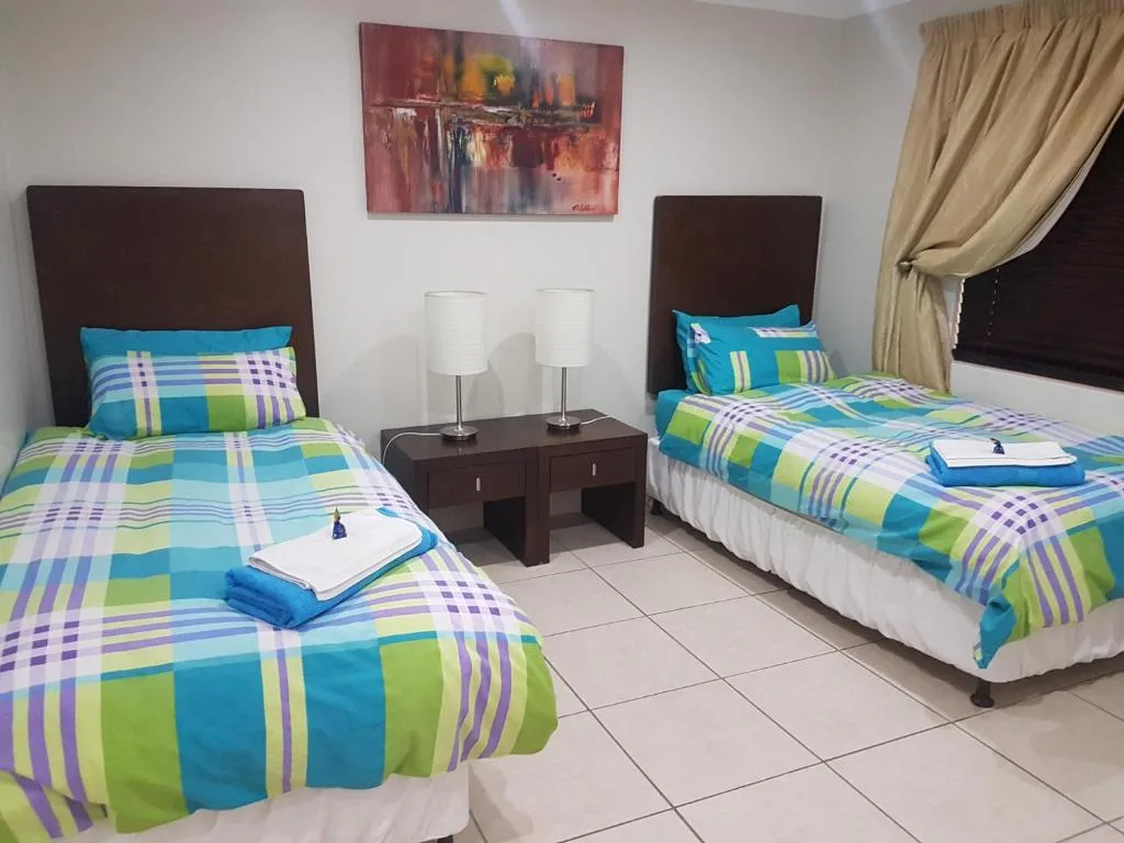 Twin bedroom with colorful patterned bedding and dark headboards