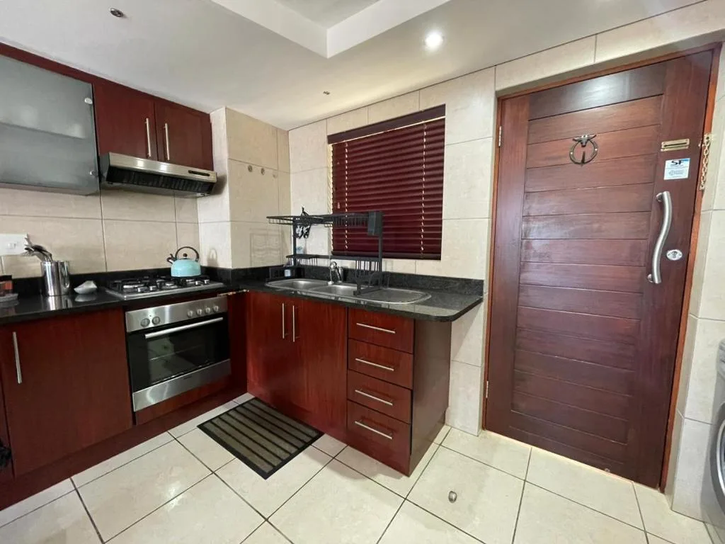 Modern kitchen with burgundy cabinetry, stainless steel appliances, and granite countertops