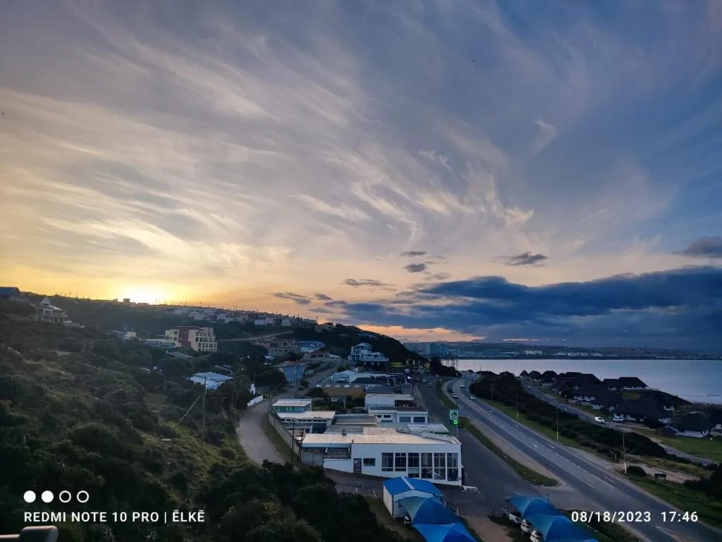 Sunset over Mossel Bay lagoon with coastal town and mountains