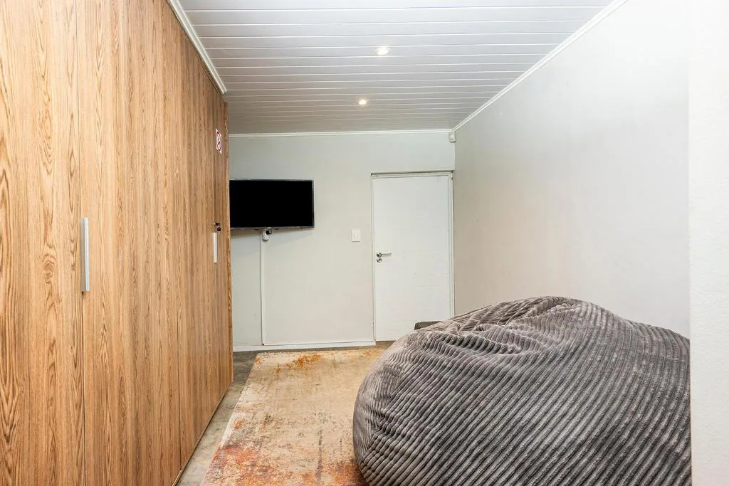 Modern bedroom with wooden wardrobe and wall-mounted television
