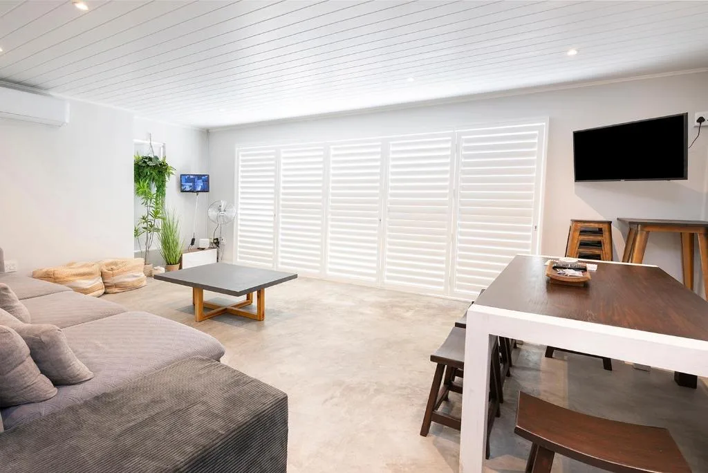 Open-plan living area with gray sofa, flat-screen TV, and modern furnishings