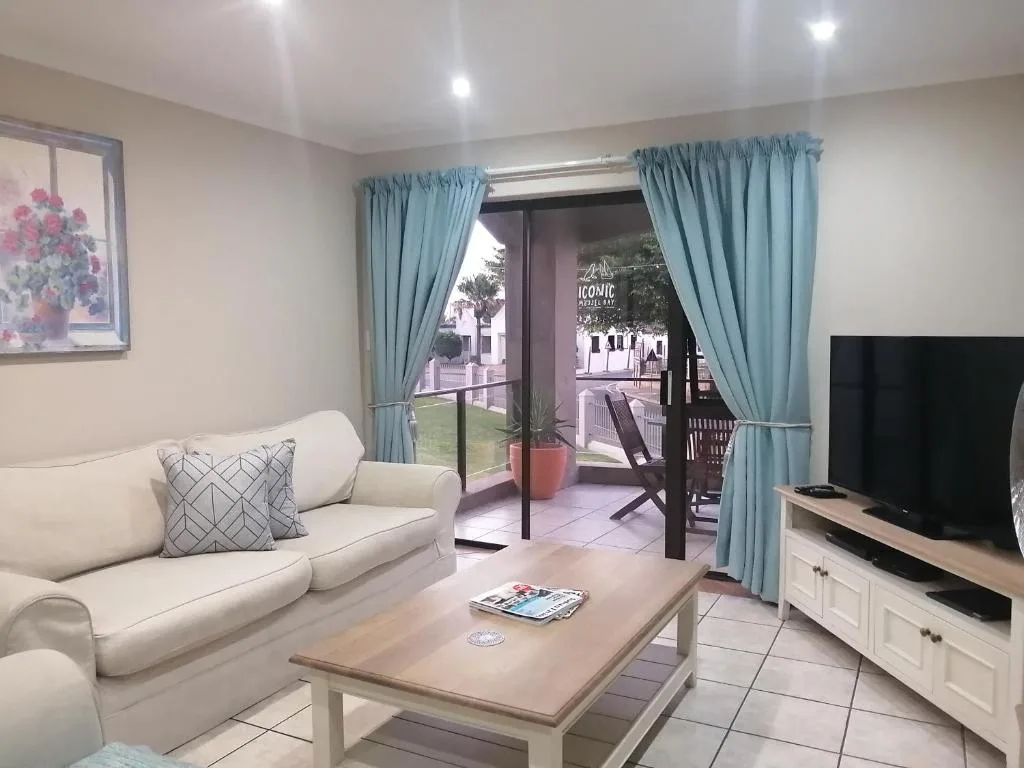 Bright living room with cream sofa, wooden coffee table, and sliding glass doors