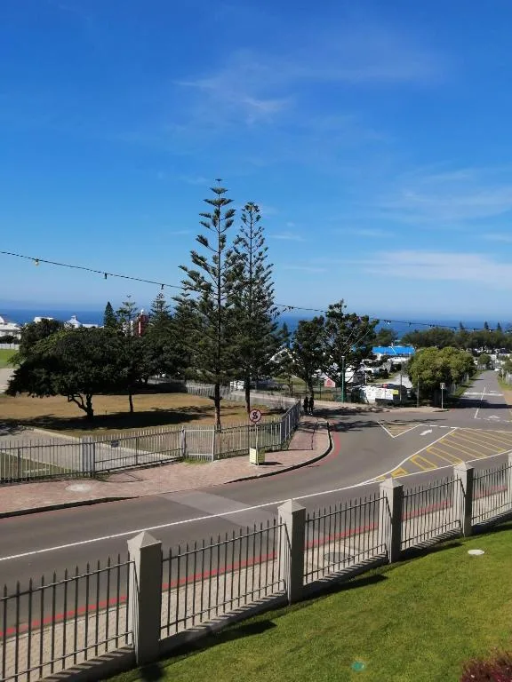 Ocean vista with coastal town and pine trees beyond property fence