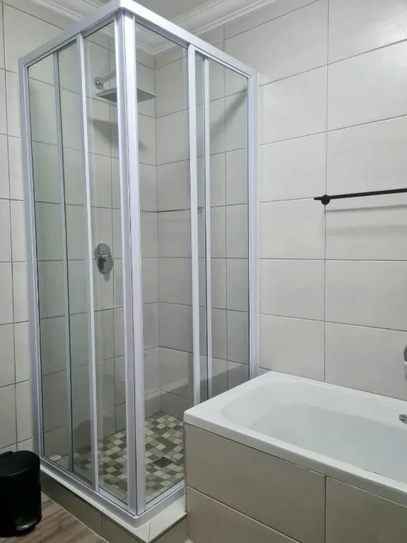 Modern bathroom with glass shower enclosure and white subway tile walls