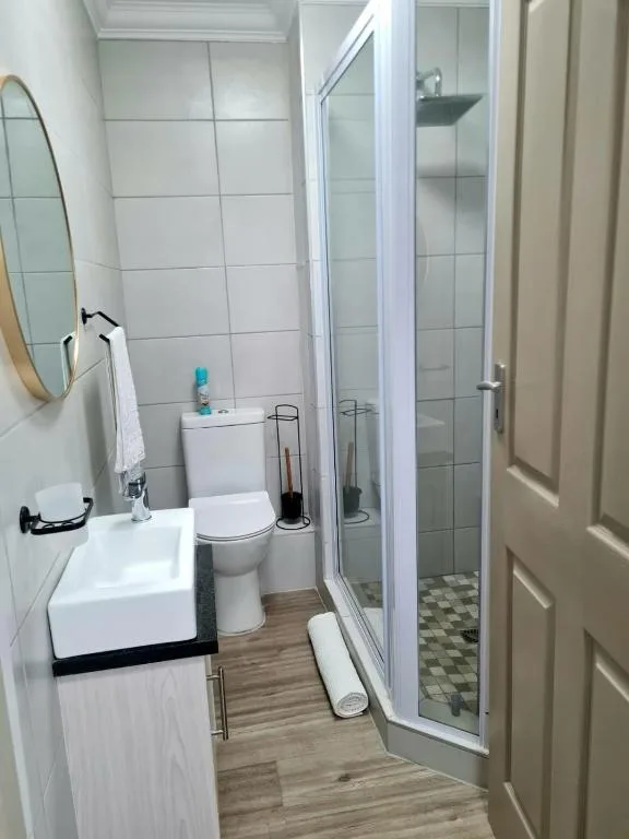 Modern bathroom with shower enclosure, toilet, and white sink vanity