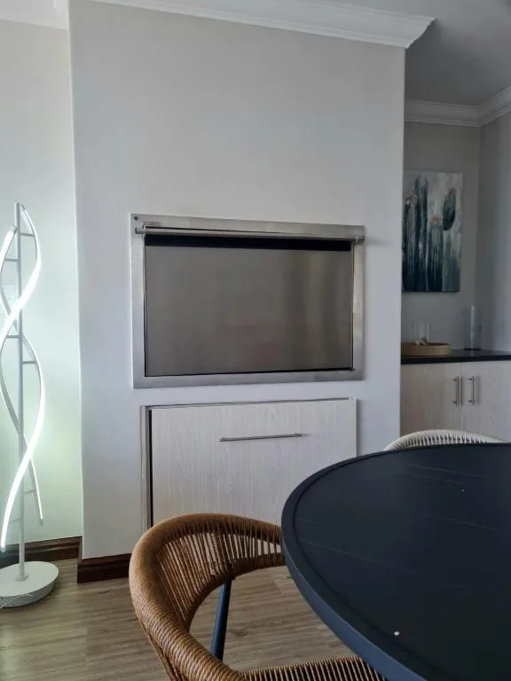Modern living room with wall-mounted TV, woven chair, and contemporary decor