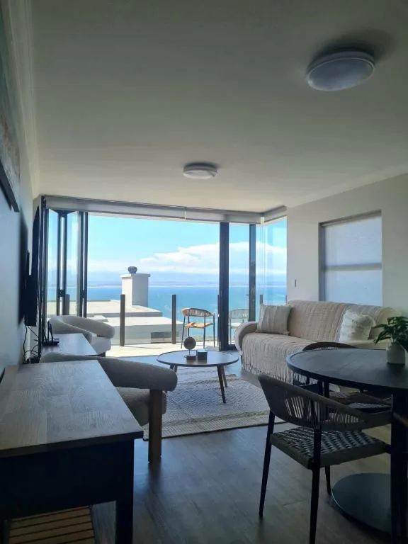 Modern lounge with ocean view through large glass doors and windows